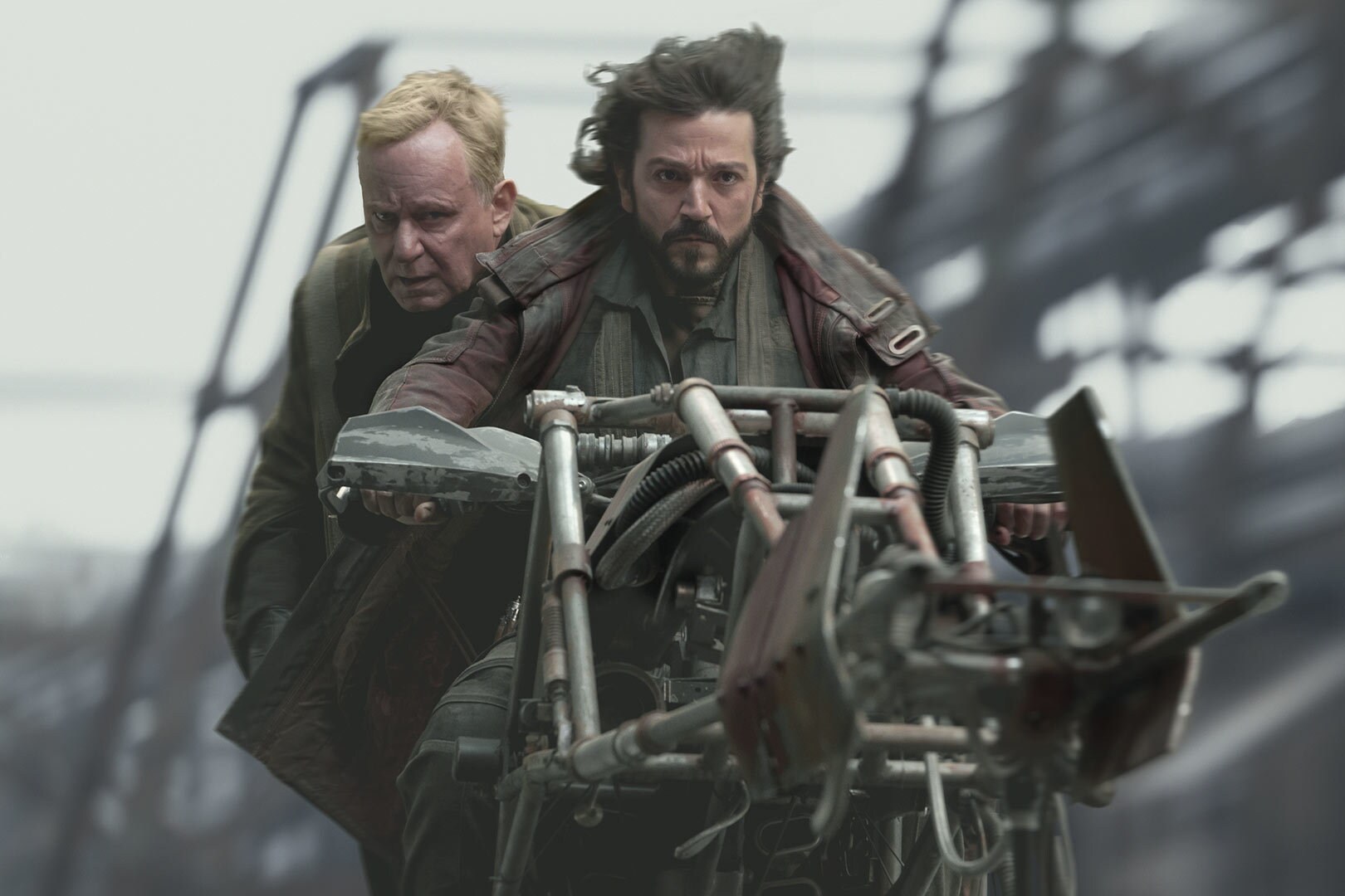 Cassian Andor and Luthen Rael riding a hoverbike together
