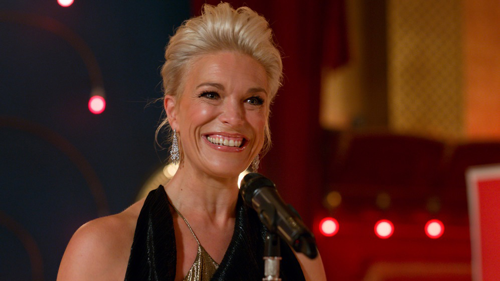 Rebecca Welton smiling with a microphone