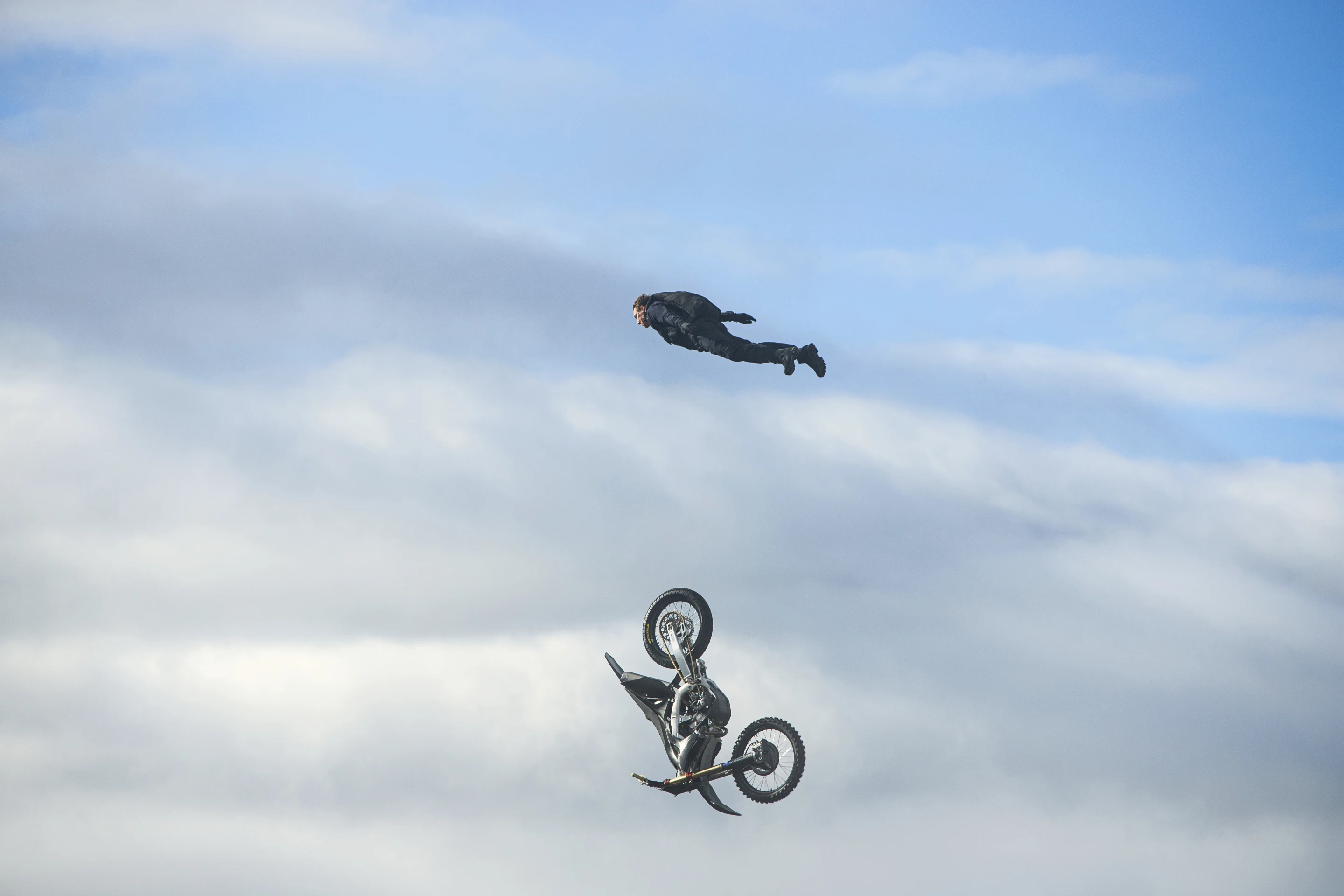 Tom Cruise soaring through the air as a motorbike falls away